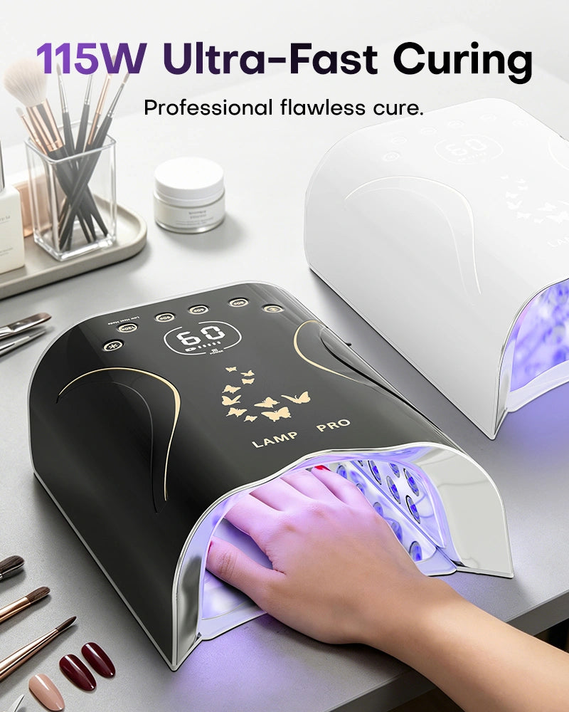 Nail tech curing a client's hand inside the black 115W high-power gel nail lamp. Ensures ultra-fast, professional flawless curing for acrylics and hard gels. The lamp's digital screen is blank, sitting next to a white model on a tidy manicure station