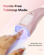Hands-free tabletop mode. Pink Gugusure nail lamp standing upright on a desk to streamline your flash cure routine.