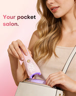 Your pocket salon. Woman packing a compact pink Gugusure cordless UV LED nail lamp into her purse for travel.