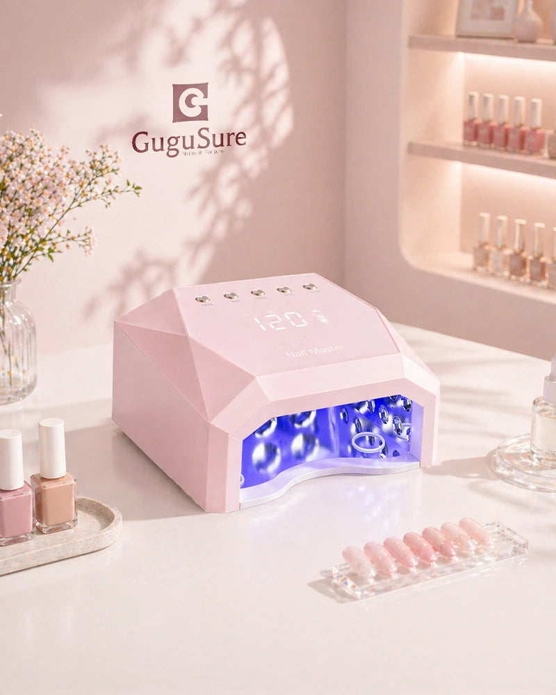 A soft pink GuguSure UV LED nail lamp sitting elegantly on a manicurist workstation equipped with premium nail accessories and top coats. This highly efficient professional nail drying machine is engineered to significantly speed up curing times for gel nails while maintaining a chic, professional look that perfectly complements any modern nail salon decor or mobile nail tech's essential toolkit.