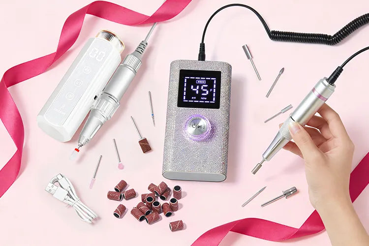 Flatlay display of Gugusure nail drill collection, including the luxury rhinestone model and holographic white portable E-file with sanding bands.