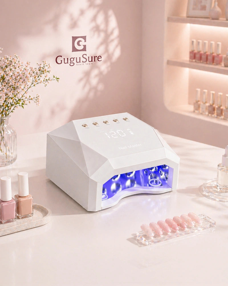A sleek white GuguSure professional UV LED nail lamp placed on a clean minimalist salon desk alongside pastel gel polish bottles and nail swatches. This high-power gel nail curing light features a convenient digital smart display and multiple timer settings including a comfortable 120S low heat mode, making it an ideal choice for professional nail technicians and advanced at-home users seeking fast, salon-quality drying results for gel extensions.