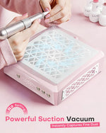 Nail technician filing acrylic nails over a pink aluminum nail dust collector. The powerful suction vacuum instantly captures fine dust, preventing spills and keeping the manicure workspace clean and safe.