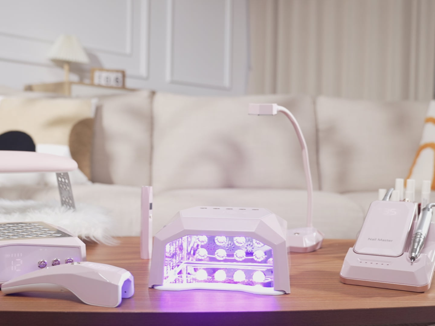 Cozy living room DIY manicure station featuring a complete pink Gugusure nail equipment set and colorful gel polishes.
